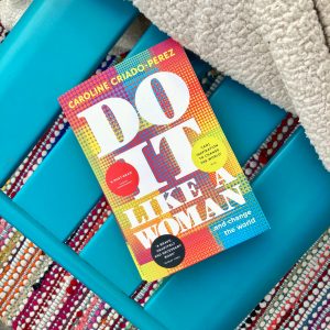 the cover of 'do it like a woman' on a chair with a blanket